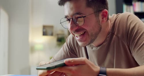 Smiling Young Adult Using Smartphone at Home