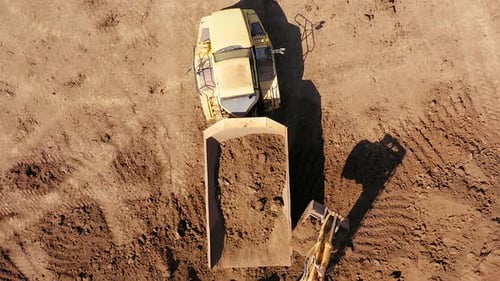 Excavators loading soil onto an Articulated hauler Truck, Aerial footage