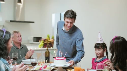 Family Celebrating Birthday with Cake and Candles