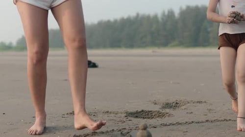 Child playing with sand on a beach, adult nearby, calm and serene atmosphere, gentle interaction, da