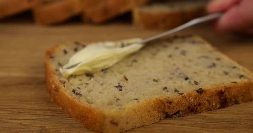 Buttering a slice of multigrain bread