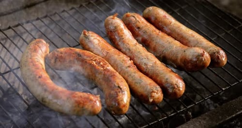 Delicious juicy sausages, cooked on the grill with a fire.