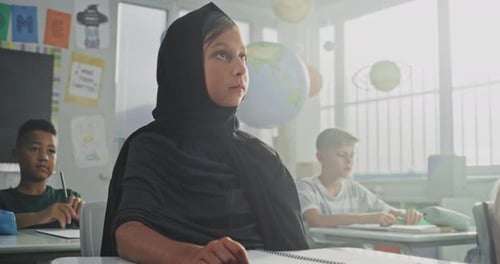 Children Sitting at Desks in Elementary School Classroom