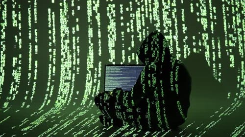 Hacker in Hoodie a fusionné avec Matrix Code alors qu'il tapait sur un ordinateur portable dans un environnement numérique totalement immersif