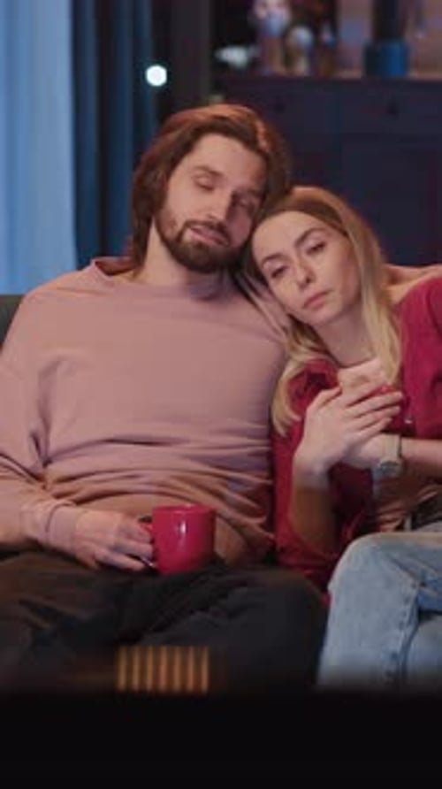 Romantic Young Millennial Adult Couple Sitting on Sofa Embracing and Talking About News Family