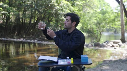 The environmentalist is testing a water Stream in the forest.