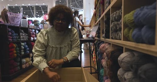 Portrait Confident Female Business Owner Restocking Shelves In Yarn Store Slow Motion