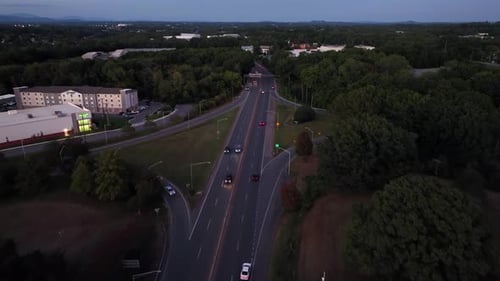 Zumbido tras la toma de un veloz coche de policía en una carretera suburbana al anochecer Verdes árboles forestales en el suburbio.