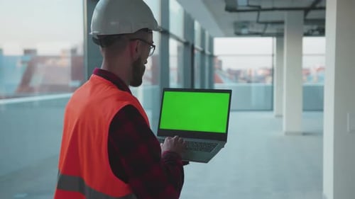Inside in Building Man Engineer Stand Using Laptop Computer with Green Screen Worker Project