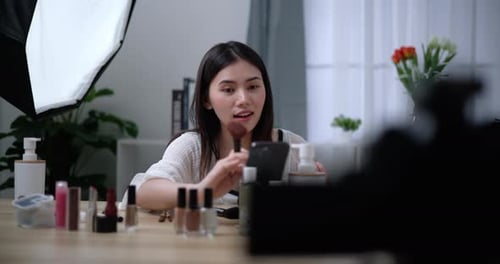 Hermosa bloguera asiática está mostrando cómo maquillar y usar cosméticos