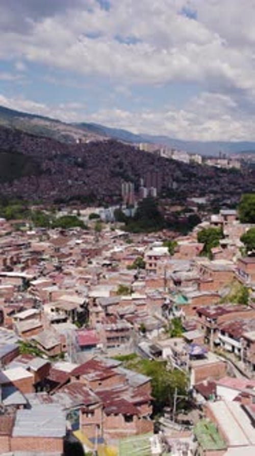 Aerial view of Comuna 13 showing colorful houses and favelas in Medellin. Vertical Video