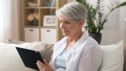 Senior woman using tablet device at home