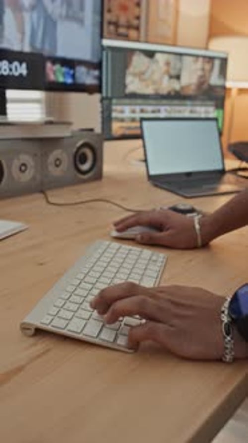 Hände eines anonymen männlichen Designers, der visuelle Inhalte am Computer bearbeitet