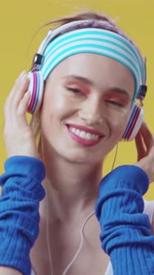 Eine modische junge Frau, die Musik genießt und dabei stylische Kopfhörer und Accessoires trägt