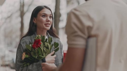 Woman Receives Flowers From Delivery Man in City