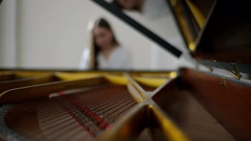 Selective Focus View From Open Lid of Music Instrument to Attractive Young Female Pianist Wearing