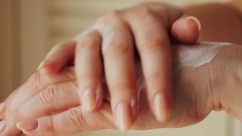 Woman Applies Cream to Her Hands