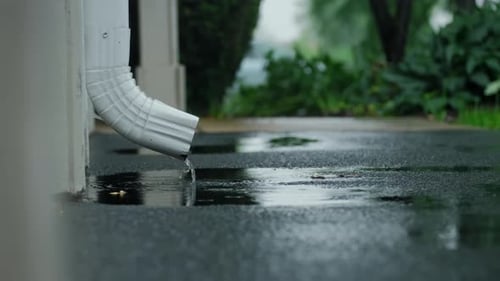 Water Flowing from Gutter Downspout on Rainy Day