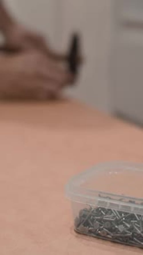 Hand Taking Nails From a Container Close Up