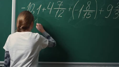 Young student solving complex mathematical formula on blackboard in school class