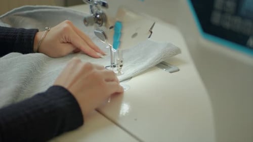 Close Up Of Gentle Hands Working On White Sewing Machine