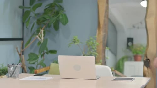 Modern Young Man Coming Back to Office and Opening Laptop
