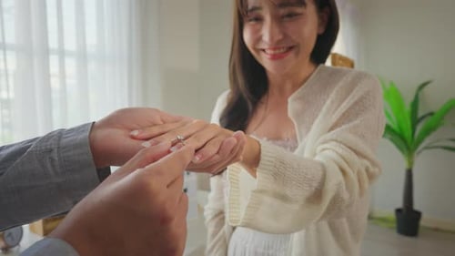 Close-up de um homem romântico surpreende a namorada com uma proposta de casamento.