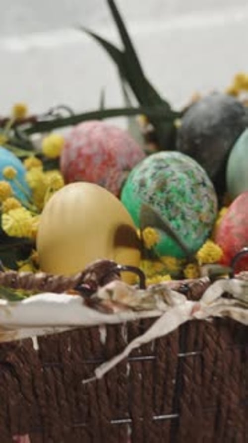 Vertical video. A woman places Easter treats on the table, self-made cakes with white icing.