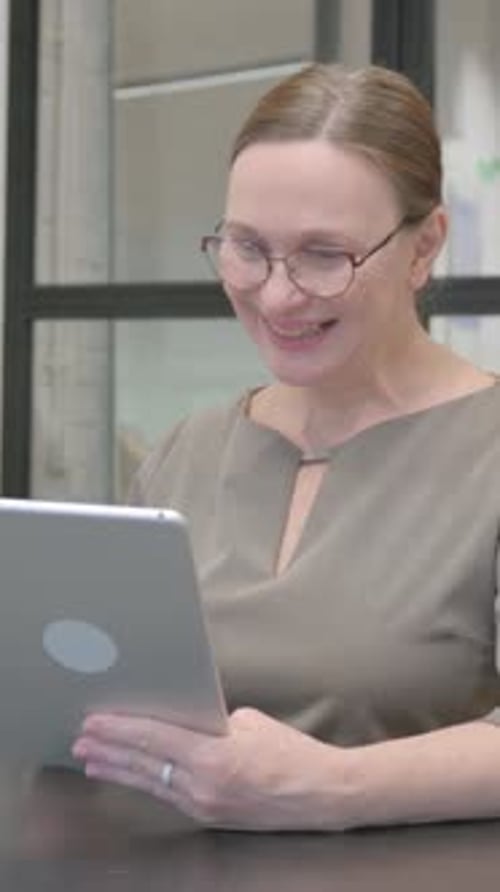 Senior Old Woman Doing Video Chat on Tablet in Office, vertical video