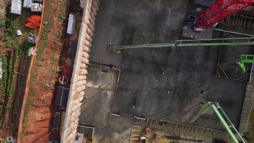 Aerial view of construction workers pouring concrete on building construction site later revealing n