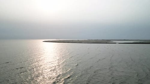 Aerial view of a seaside beach with gentle waves lapping against the shore