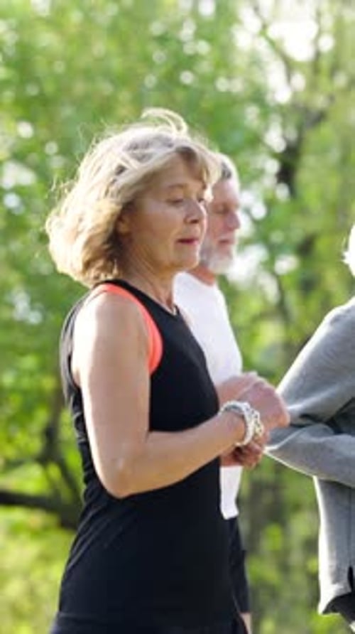 Active Mature Couple Jogging Through Park