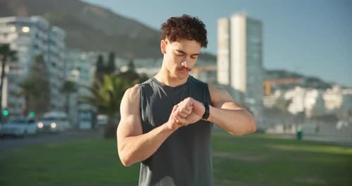 Man Checks Smartwatch During Outdoor Workout in City