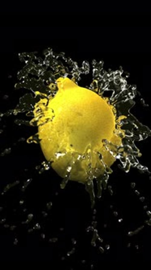 Rotating Lemon with Dynamic Water Splash on Black Background