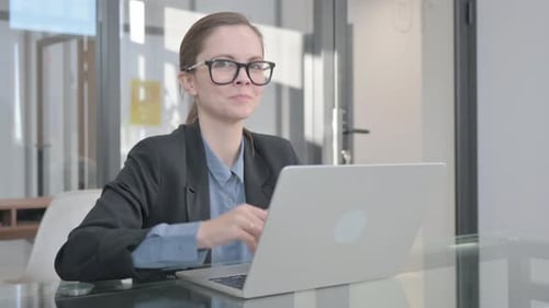 Businesswoman Working on Laptop Gives Thumbs Up