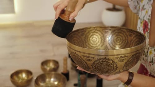Woman Plays Singing Bowl for Meditation and Relaxation