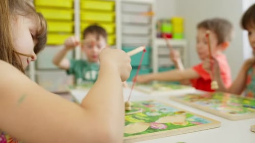 Children Learn and Play Educational Games with a Teacher in Kindergarten