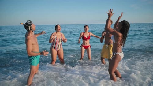 Fröhliche Freunde genießen einen verspielten Tag am Strand und planschen lachend im erfrischenden Wasser