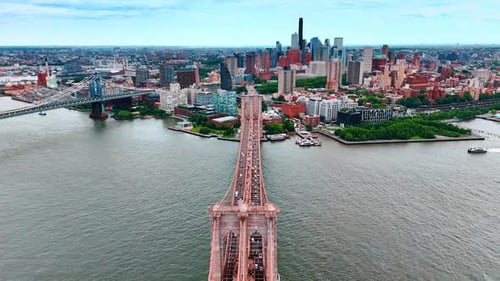 Flying above the gorgeous Brooklyn Bridge with multiple cars moving on the Manhattan Bridge
