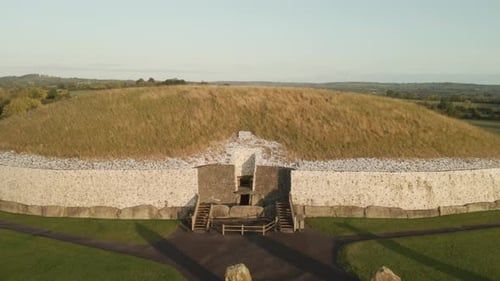 Entrance Of Newgrange Monument At Sunrise In County Meath, Ireland. - aerial pullback shot