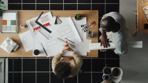 Architects Discussing Blueprints at a Table