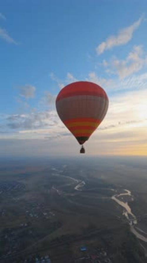 Birdseye View of Beautiful Colorful Hot Air Balloon Floating in Picturesque Evening Sunset Sky
