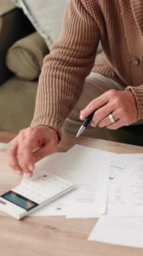 Man Works on Paperwork at His Home Office