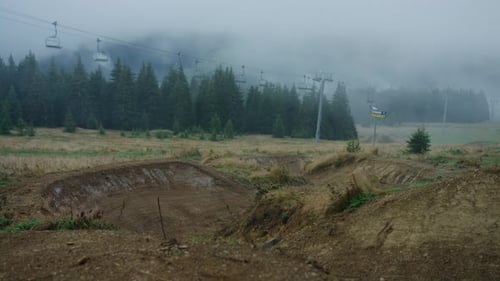 A mountain bike racer is riding down a trail very fast