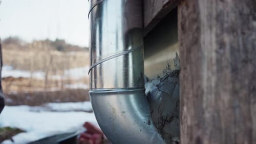 Man Building DIY Hot Tub Sealing The Gaps Behind The Chimney With Mortar Paste. - close up shot