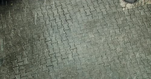 Hagel und Starkregen auf Pflastersteinen in der europäischen Stadt