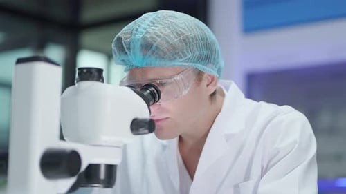 Scientist Looks Through Microscope in Lab