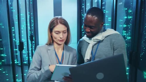 Two Colleagues Work With Servers and Technology