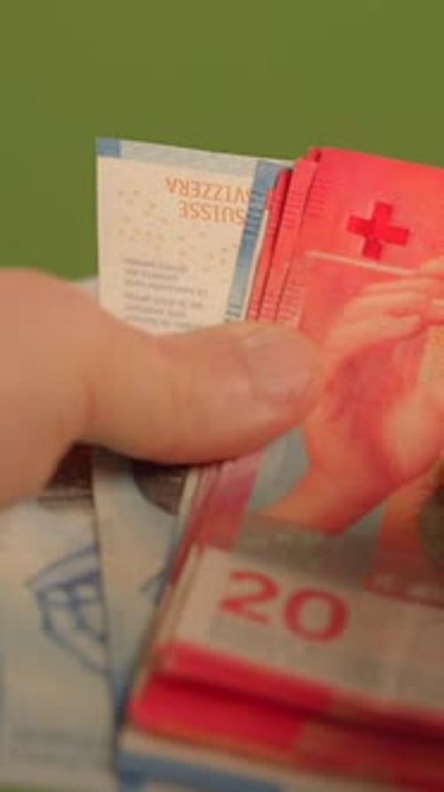 Gros plan de la monnaie suisse en main sur une scène de fond lumineuse et vibrante