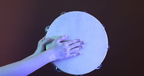 Hands Playing a Tambourine in Close Up